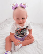 Little girl is wearing a pair of handmade clip bow for toddler girls from By Bella Boutique.